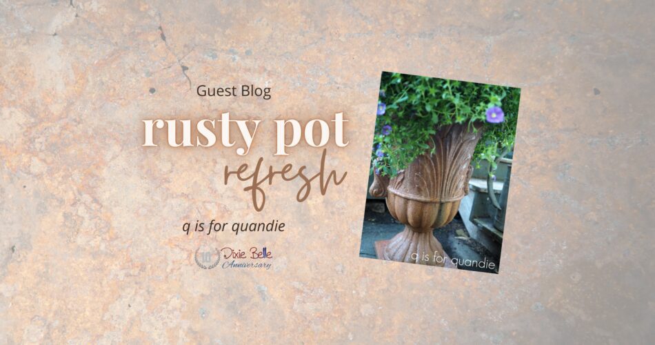 A photo of a brown planter pot sitting on a cement ground with greenery and purple flowers coming out of the top. The background behind the photo is brown rust, and the words Guest Blog rusty pot refresh q is for quandie Dixie Belle 10th Anniversary are printed to the left of the photo.