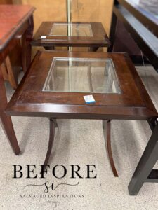 A picture of two brown wooden side tables with clear glass in the center.