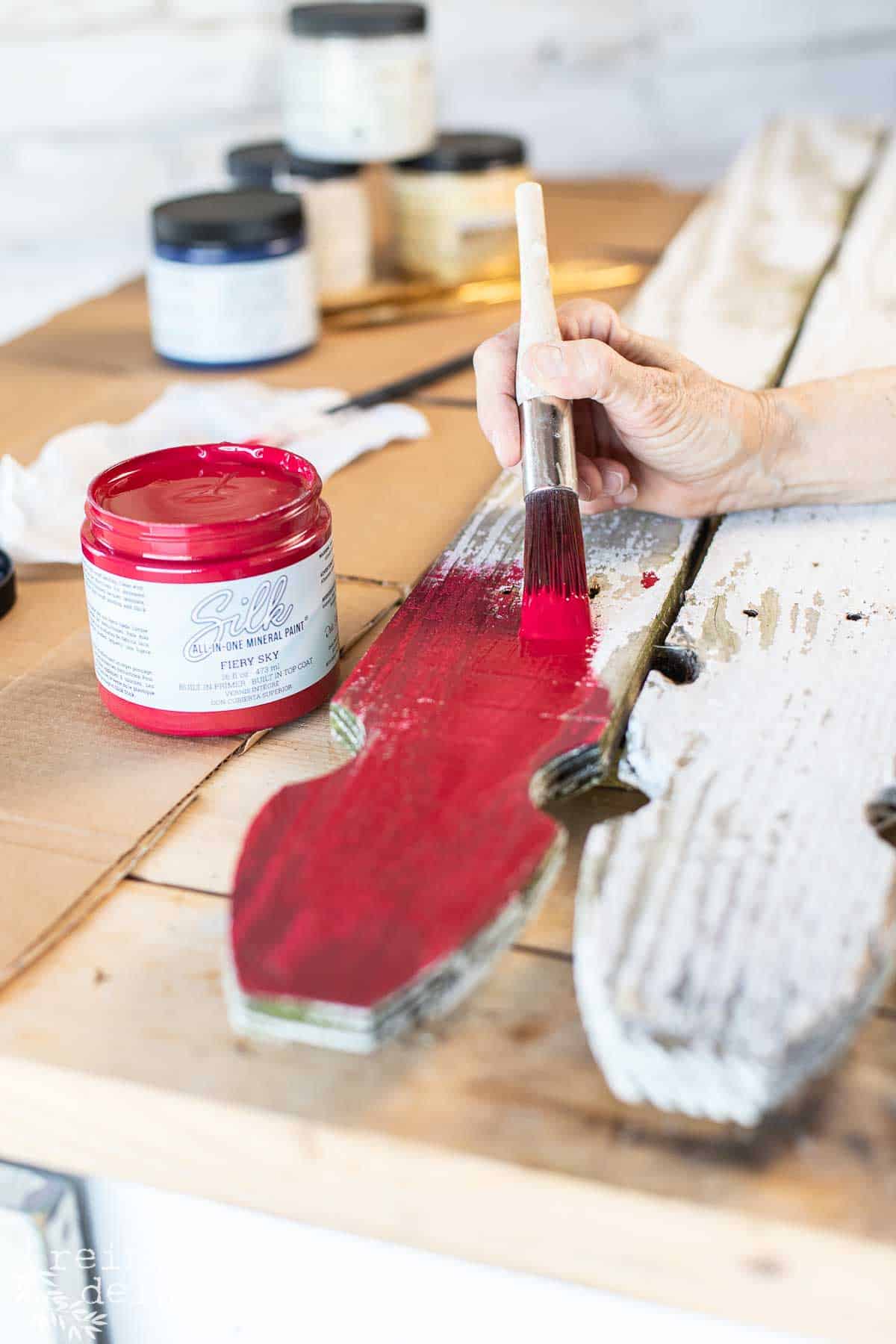 Applying Fiery Sky Silk All-In-One Mineral Paint to one picket of the American flag.