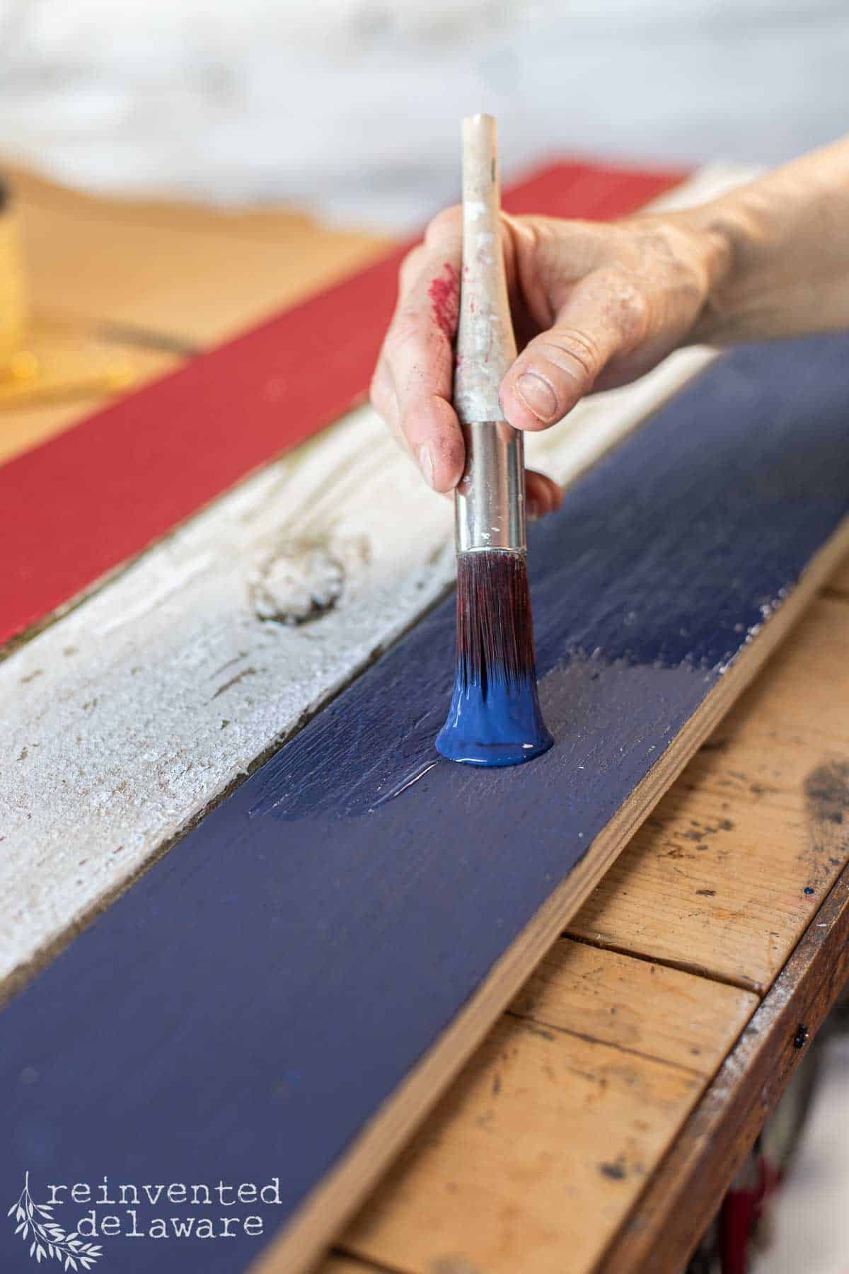 Applying Nautical Silk All-In-One Mineral Paint to the final picket of the American flag.