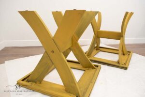 Two yellow tables sitting upside down on a white piece of paper.