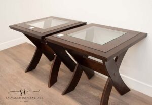 A picture of two brown wooden side tables with clear glass in the center.