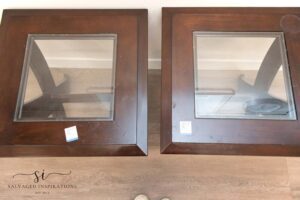 A picture of two brown wooden side tables with clear glass in the center.