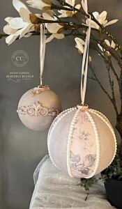 two round ornaments painted with Dixie Belle paint hanging from brown branches