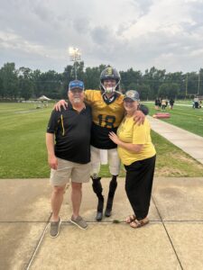 Photo of Calder H with family members on a football field