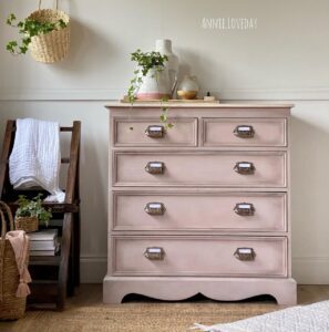 A photo of a dresser painted with Tea Rose Chalk MIneral Paint sits on a brown wooden floor, in front of a white wall