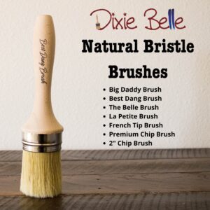 The Best Dang Brush stands on it's bristles on a brown stained table; Dixie Belle natural bristle brushes are listed to the right of the brush